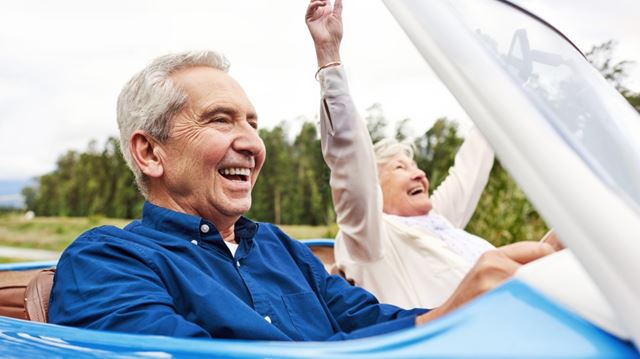 Should you buy a convertible car senior couple driving convertible smiling